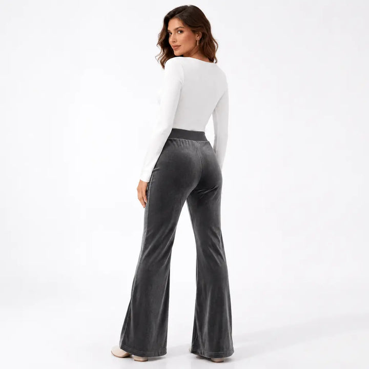 Dark gray velvet flare pants back view with face visible, plain rear styling, high waistband, rear seam and wide flared legs.