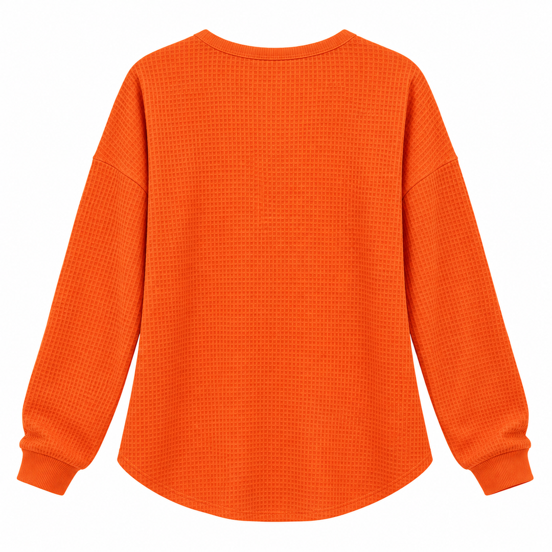 Orange waffle long sleeve pullover shown flat from the back with relaxed shape and textured surface