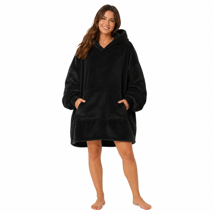 Black wearable blanket hoodie with hood and large front pocket modeled by a woman on a clean white studio background.