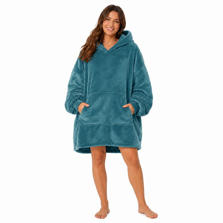 Blue wearable blanket hoodie with hood and large front pocket modeled by a woman on a clean white studio background.