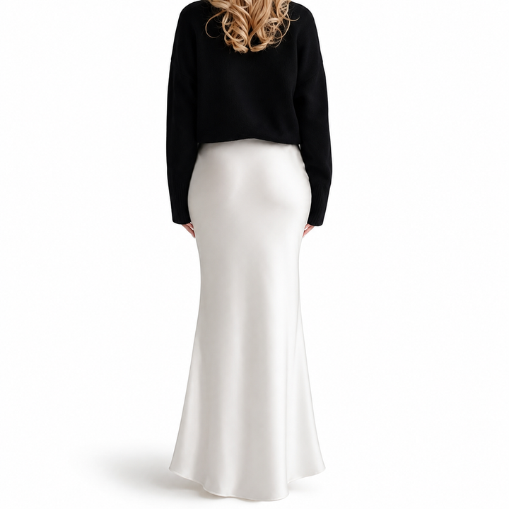 Back view of white high-waisted maxi skirt on model, showing smooth hip line, long flowing length and softly flared hem detail.