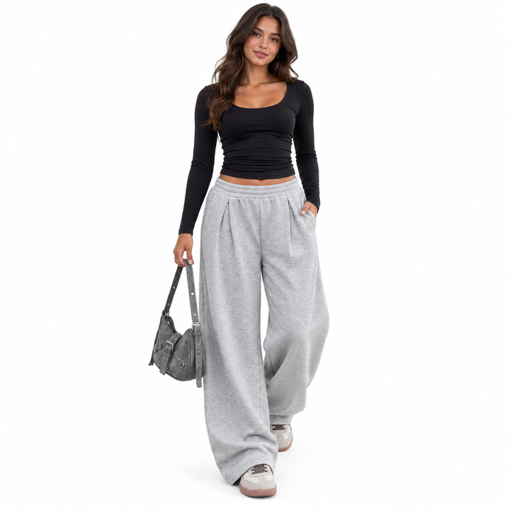 Gray pants styled with a black top and small bag