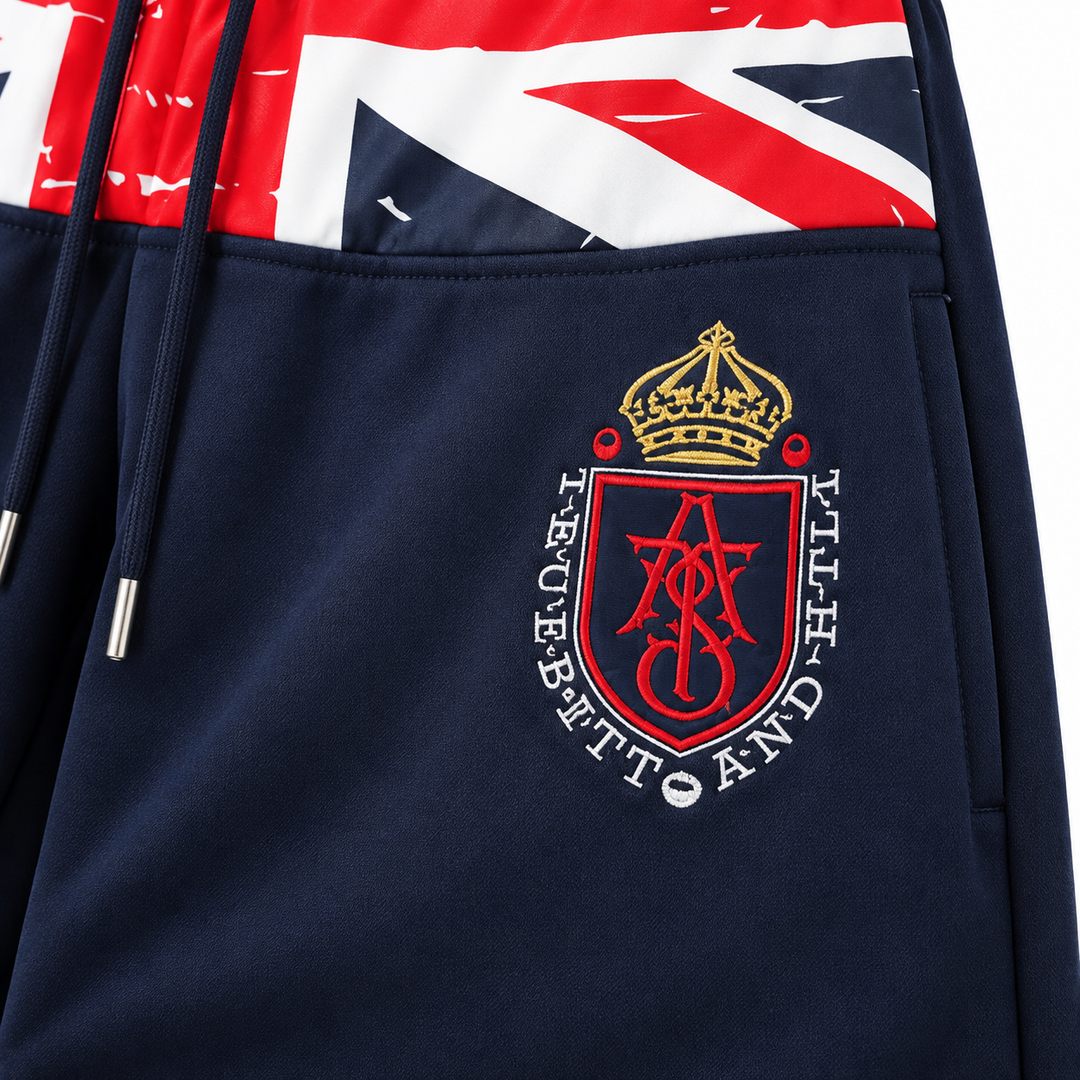 Close-up of crest embroidery and navy fabric on wide leg sweatpants