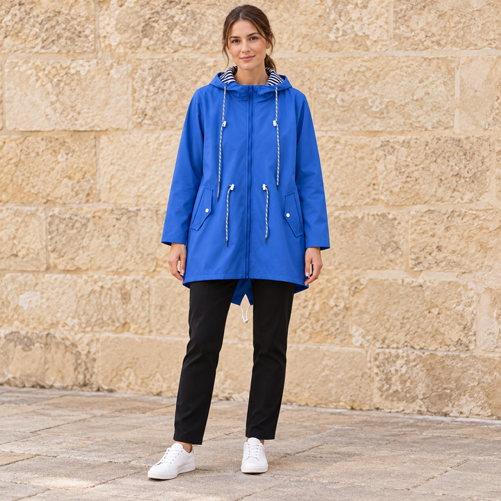 Full-body model wearing a blue hooded zip-front windbreaker.
