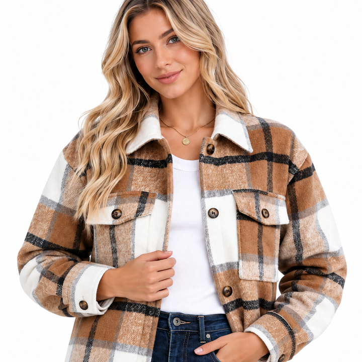 Close product view of the plaid shacket showing collar, chest flap pockets, buttons and visible fabric texture on white.