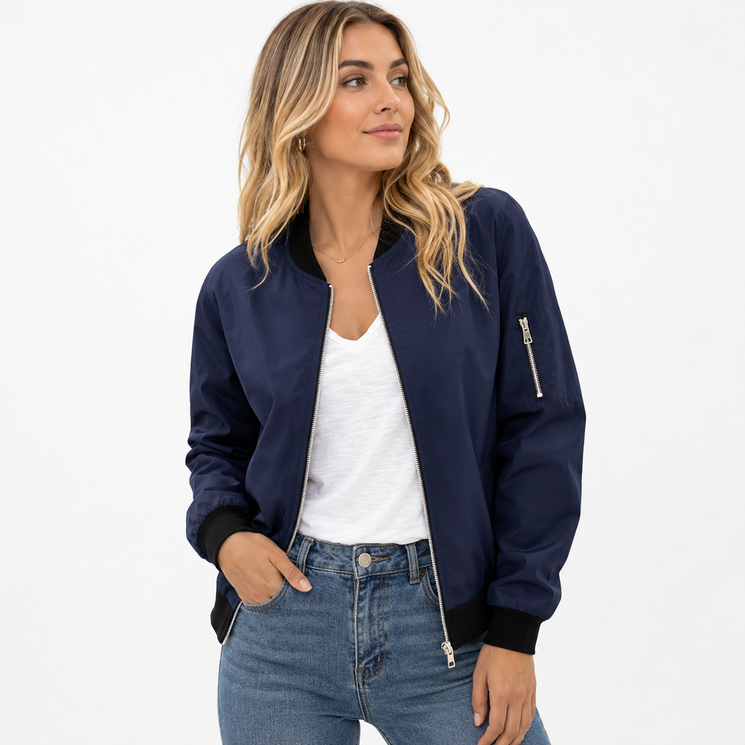 Women's bomber jacket in navy on a model, front studio view showing zip closure, black ribbed trim and sleeve zipper pockets.