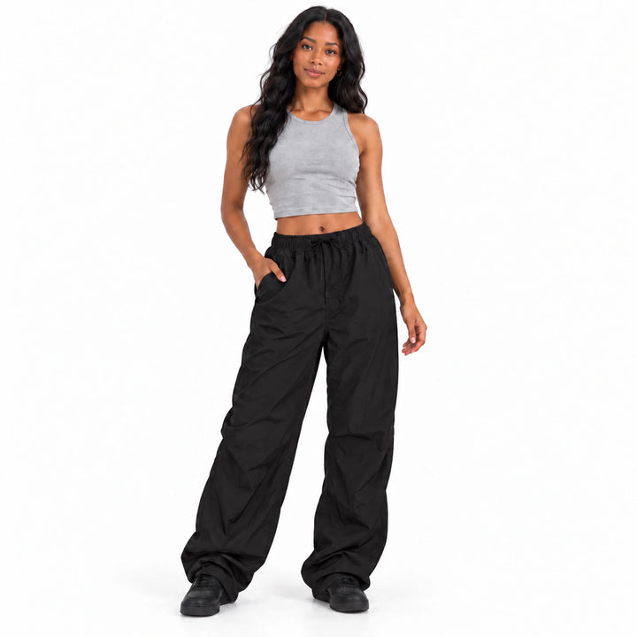 Black cargo pants worn by a model, shown from front against a white background to display their relaxed waist and loose legs.