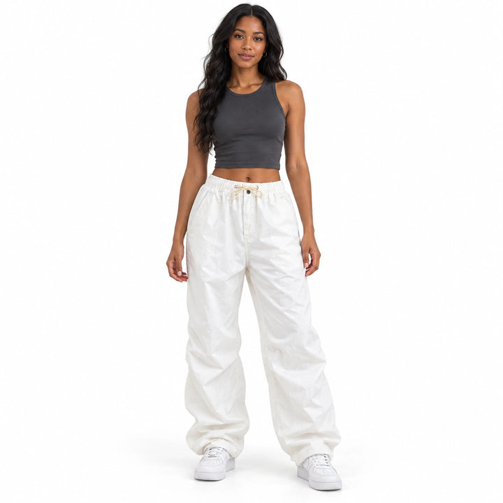 Front studio view of white drawstring cargo pants on a model, showing the loose leg silhouette, gathered waist and long hems.