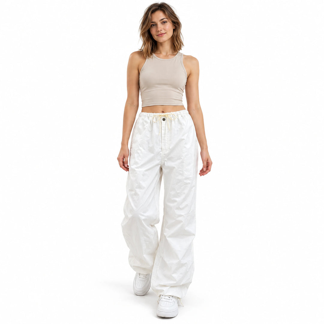 White drawstring cargo pants front view on a model, showing the loose full-length leg shape and low-rise waist in the studio.