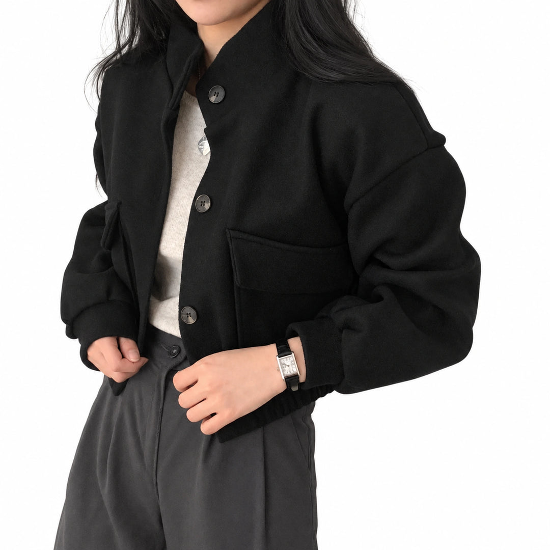 Black cropped jacket with three buttons and an open patch pocket, shown on an adult model