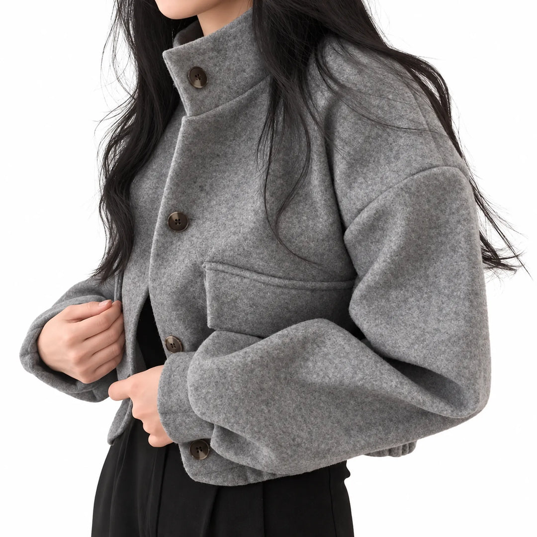 Grey cropped button jacket worn by an adult model at a three-quarter angle