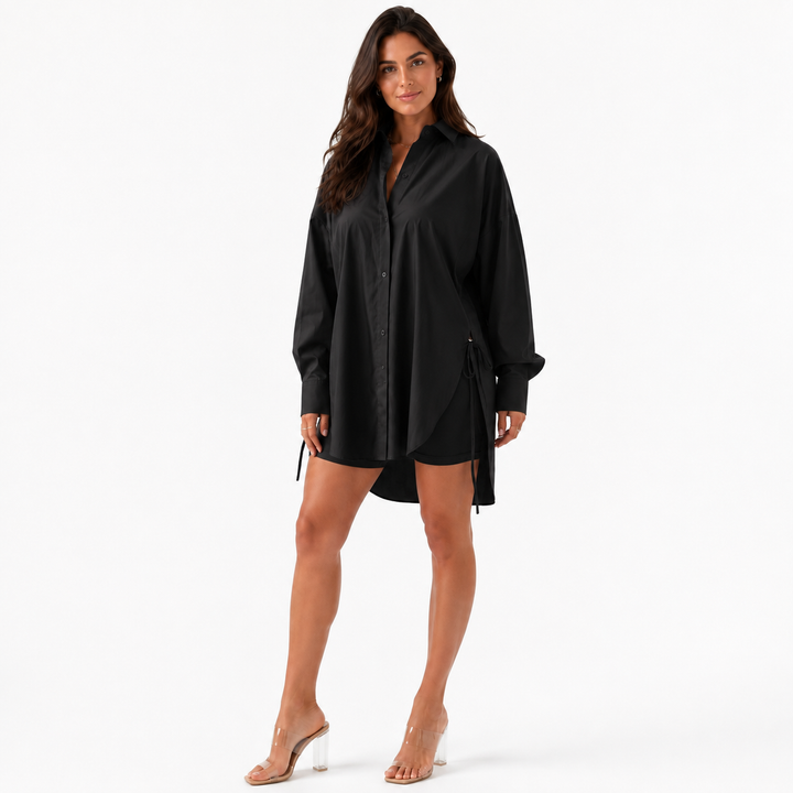 Woman wearing the black oversized drop shoulder long sleeve shirt on a white background with clear fabric detail.