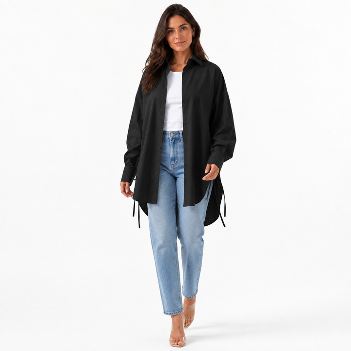 Black oversized drop shoulder shirt styled open with a white top and jeans in a clean professional studio photo.