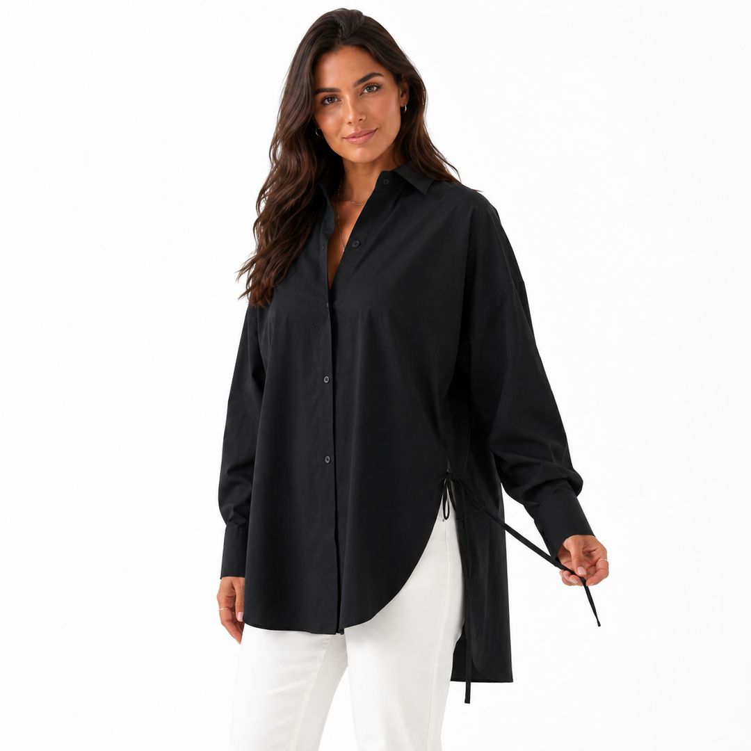 Woman presenting the black shirt side tie, curved hem, button placket and smooth polyester drape on white.