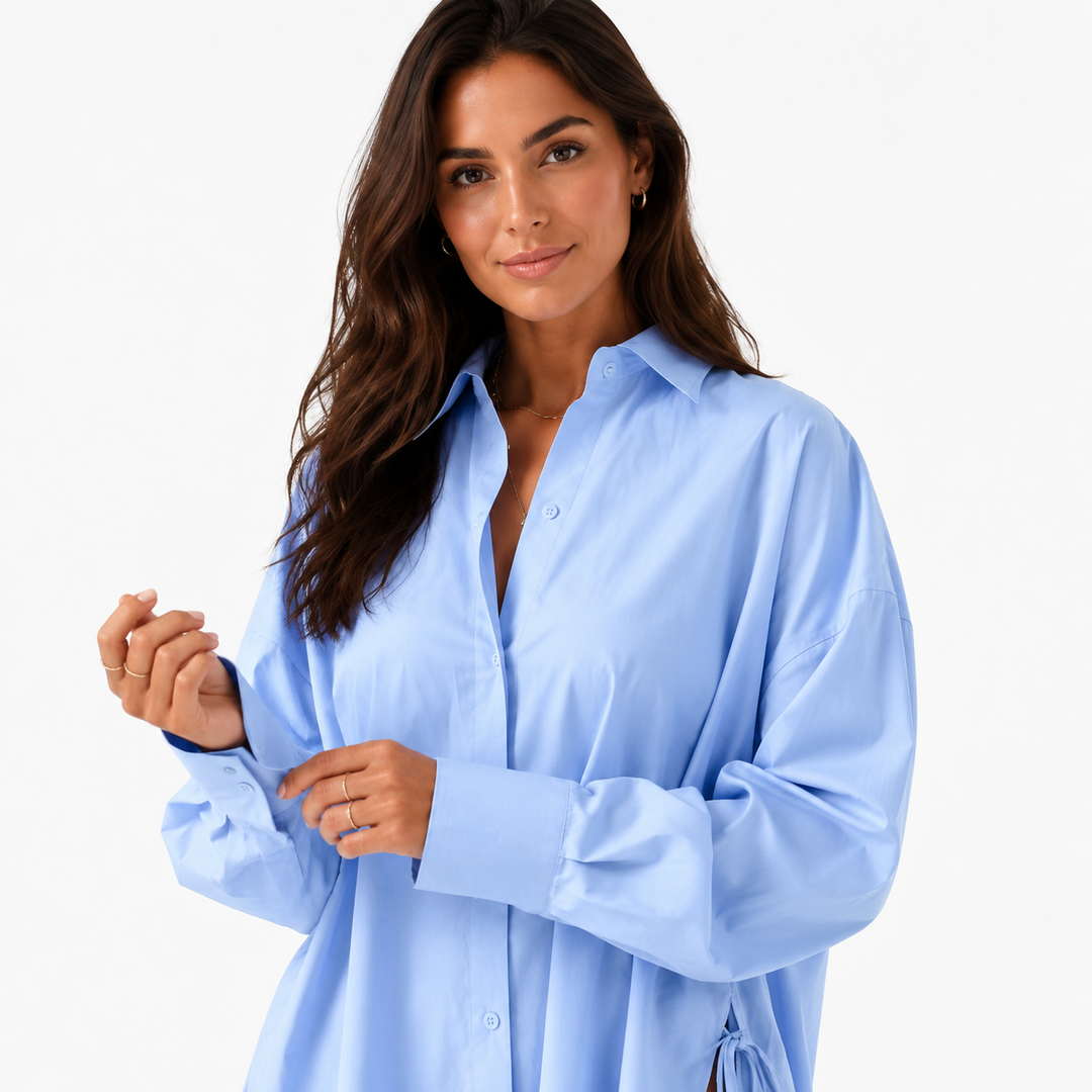 Close-up of the powder blue shirt collar, buttons, dropped shoulder seams, roomy sleeves and wide cuff finish.