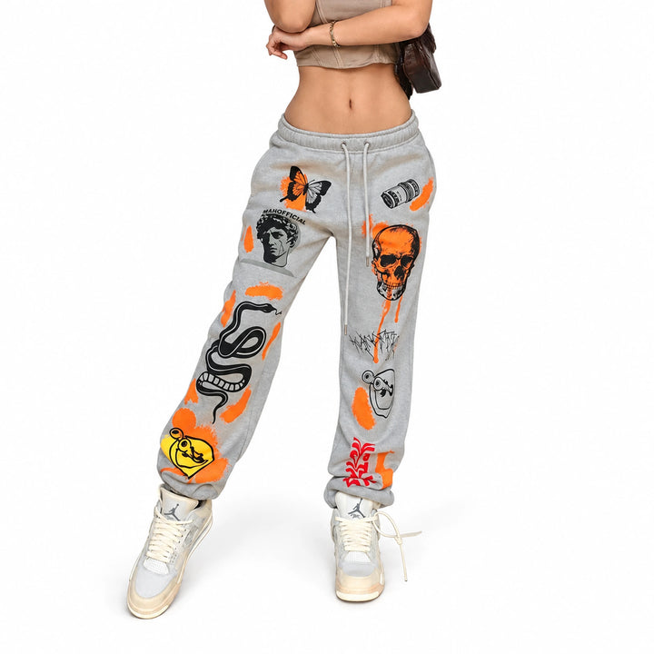 Grey drawstring joggers with orange and black graphics, shown on an adult model