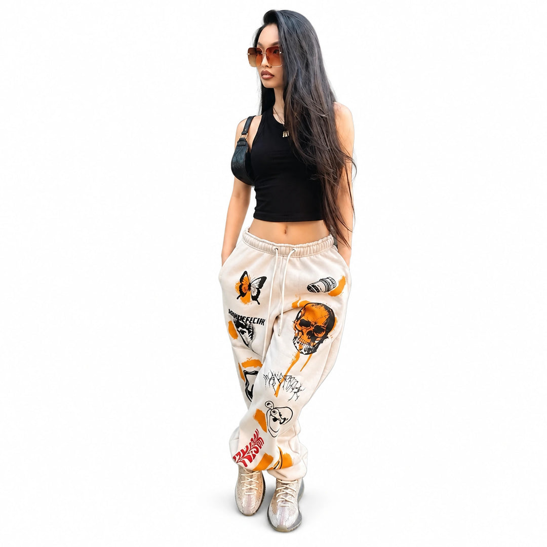 Adult model wearing white drawstring joggers with orange and black graphics, full-length view