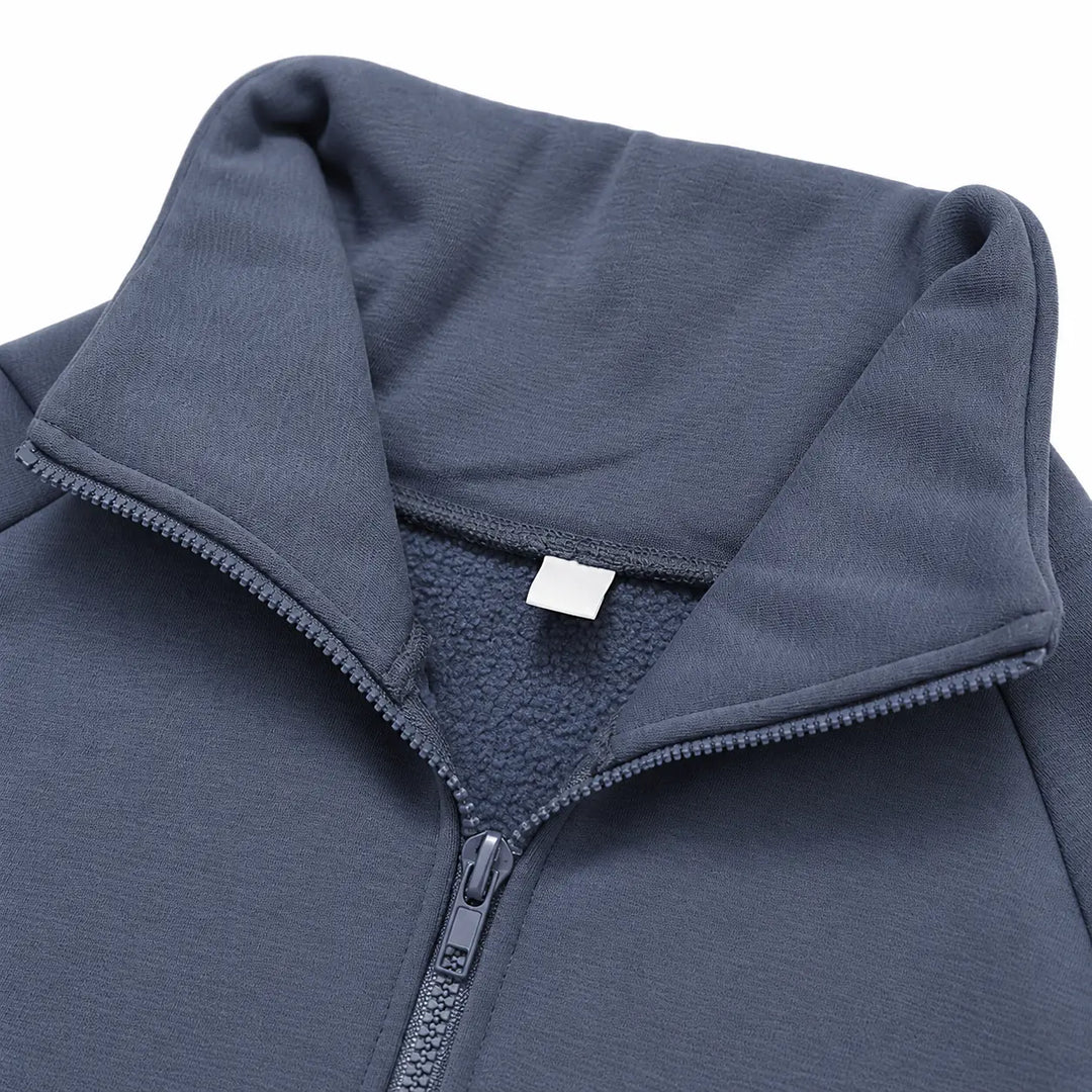 Blue-grey fleece pullover close-up showing the stand collar, half zipper and inner neckline.