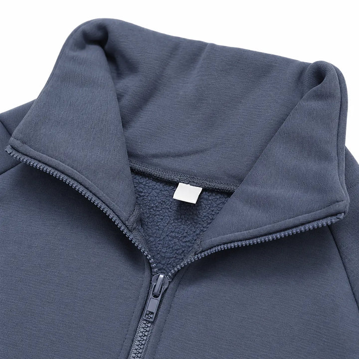 Blue-grey fleece pullover close-up showing the stand collar, half zipper and inner neckline.