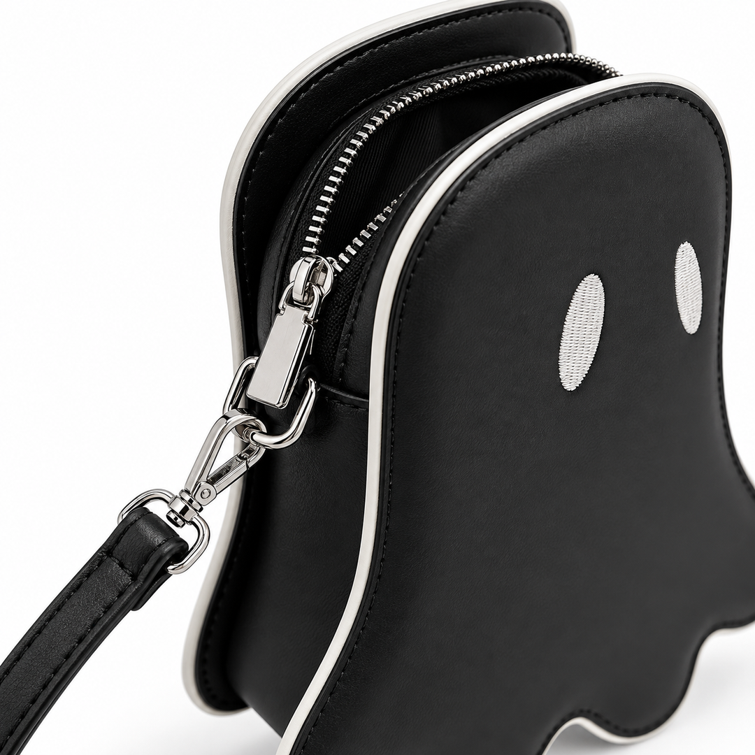 Close-up of black ghost crossbody bag zipper opening, silver clasp hardware, contrast piping and strap attachment