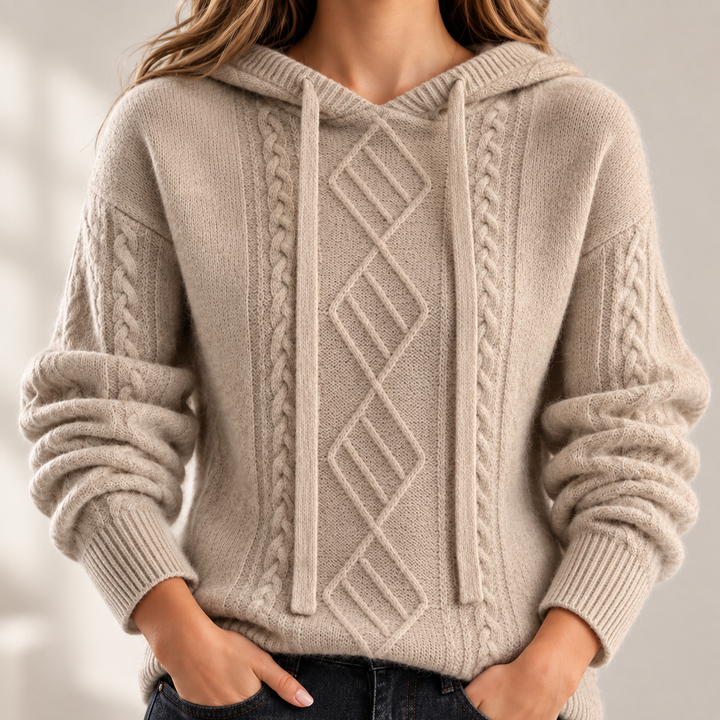 Close-up of the light camel hooded jacquard knit sweater showing the central diamond cable pattern, braided knit detail and cuffs.