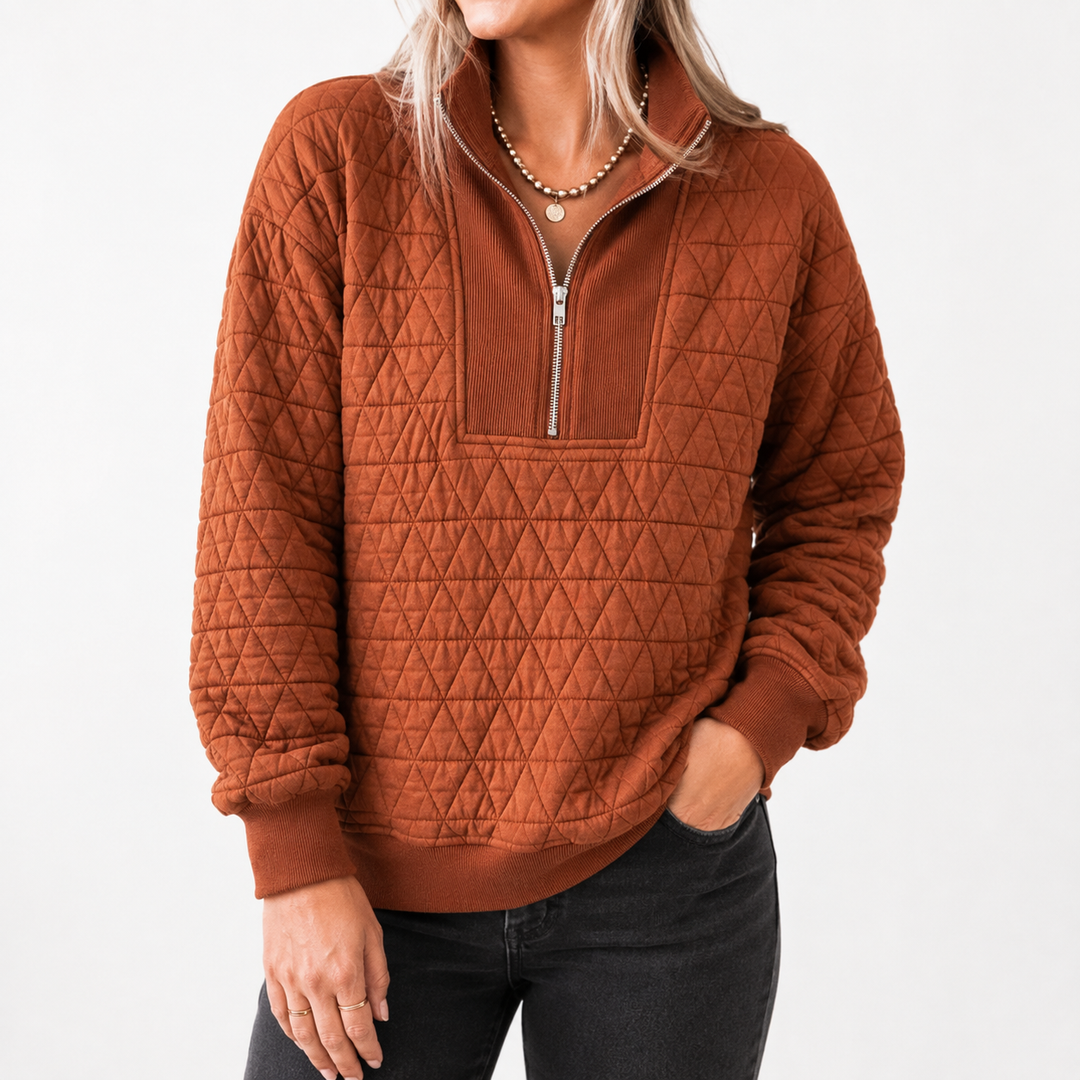 Commercial model view of the Caramel quilted half-zip sweatshirt highlighting the geometric quilting and zipper detail.