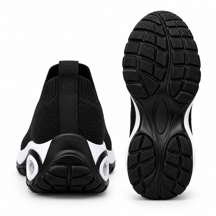 Black slip-on sneakers shown from the rear and outsole, highlighting heel pull tab, black tread pattern and wedge sole shape.