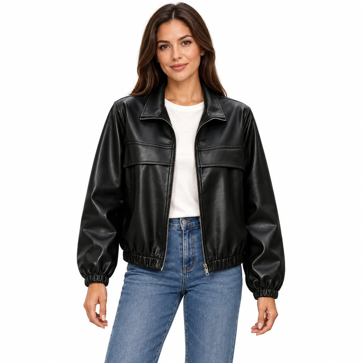 Woman wearing the Black faux leather jacket with an ivory T-shirt and blue jeans on a white background.