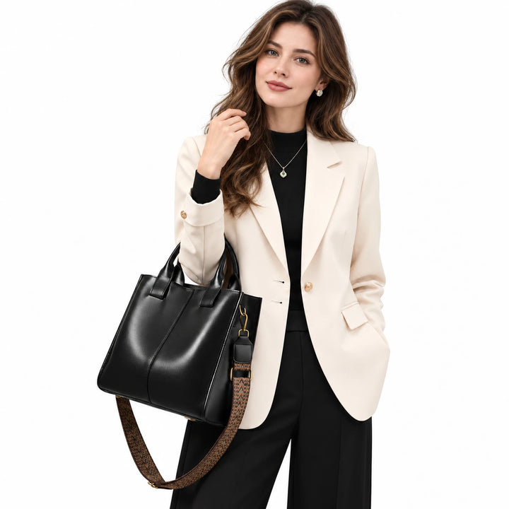 Adult model carrying a black ZENCY shoulder bag with short handles and a patterned strap