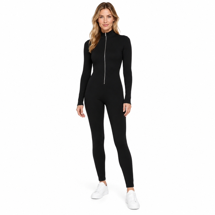 Black zip up jumpsuit on an adult model, shown head to toe with long sleeves, a zipped-up collar and white trainers on white.